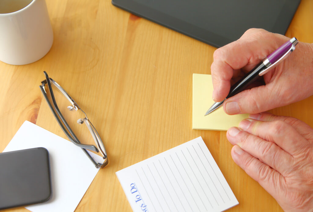 Personne écrivant son premier brouillon sur un carnet.