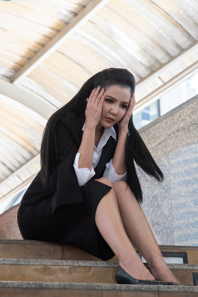 Professionnelle soutenant sa tête avec une expression d'extrême anxiété.