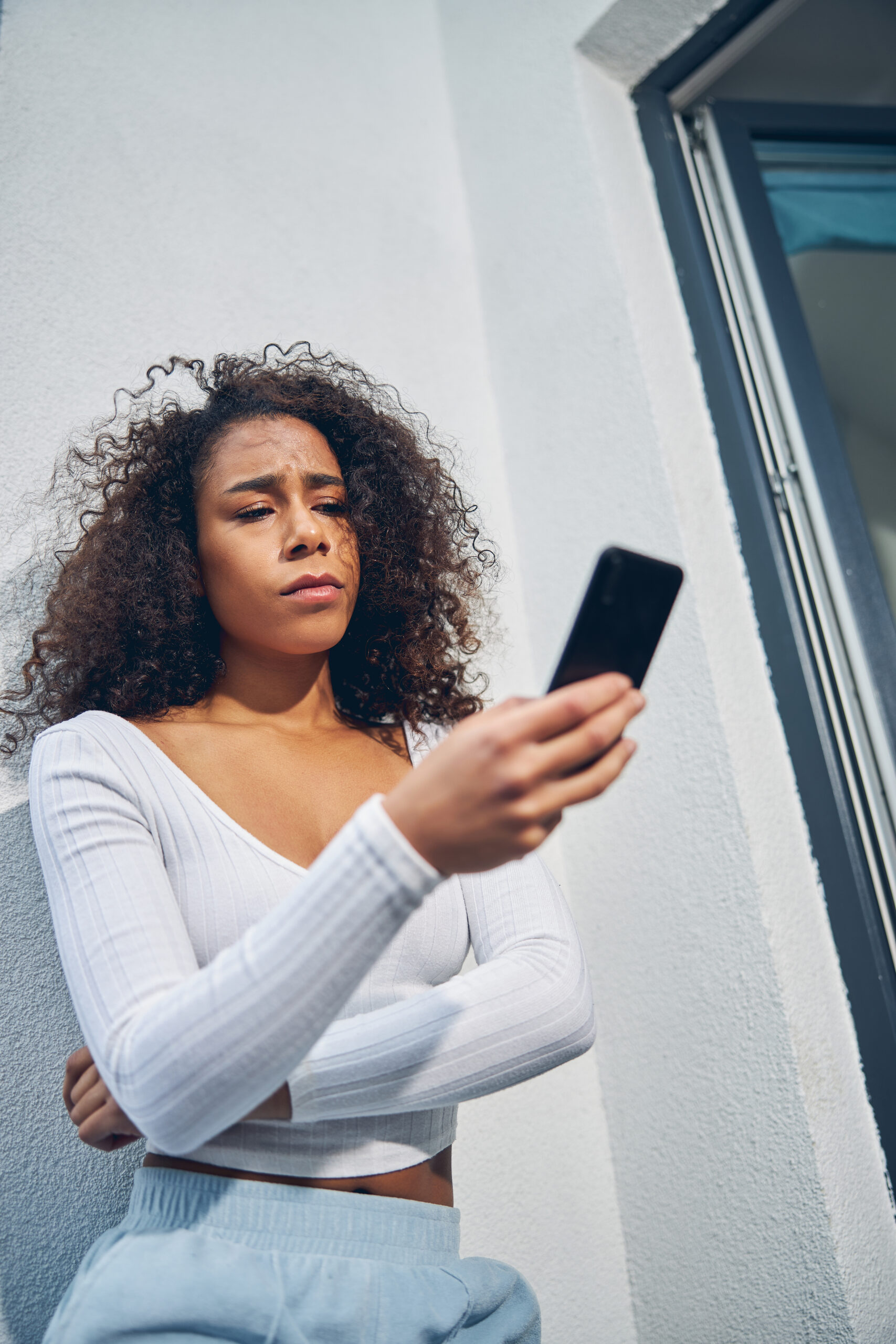 Personne regardant tristement l'écran de son smartphone affichant une conversation restée sans réponse.