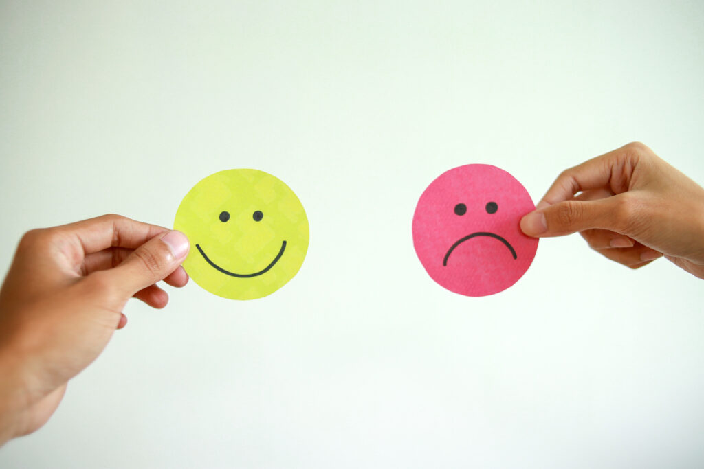 Deux smileys distinct l'un pleine de vie colorée et l'autre triste et entièrement grise.