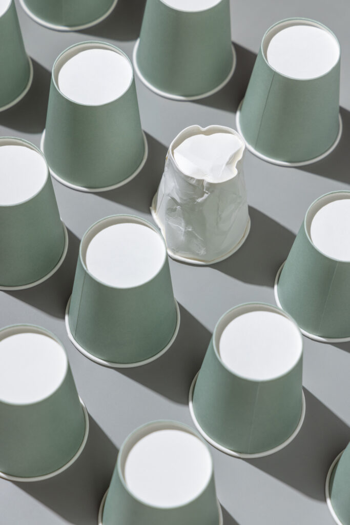 Un verre d'eau complètement déchiré posé à côté de plusieurs autres verres en parfaite état.