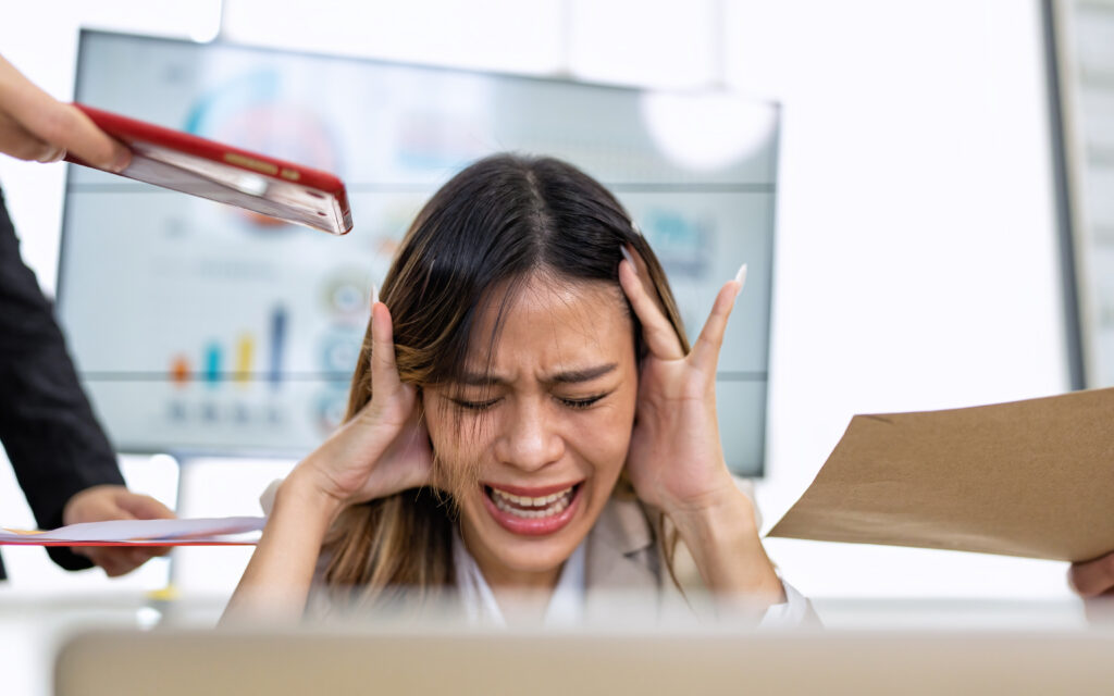 Silhouette d'une personne se tenant la tête, comme submergée par une multitude de notifications ou de gros titres de presse flottant autour d'elle.